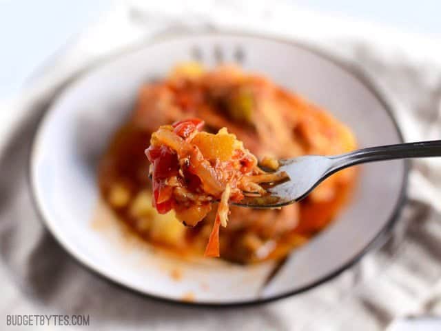 Slow Cooker Italian Chicken and Peppers is an easy dish that can be used multiple ways. Cook up a batch and use it throughout the week! Budetbytes.com Close up of a forkful of Slow Cooker Italian Chicken and Peppers