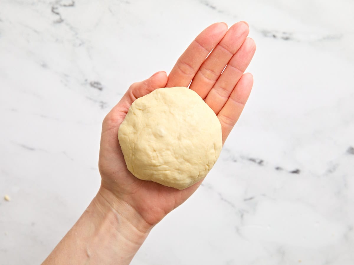 A hand holding a ball of dough.