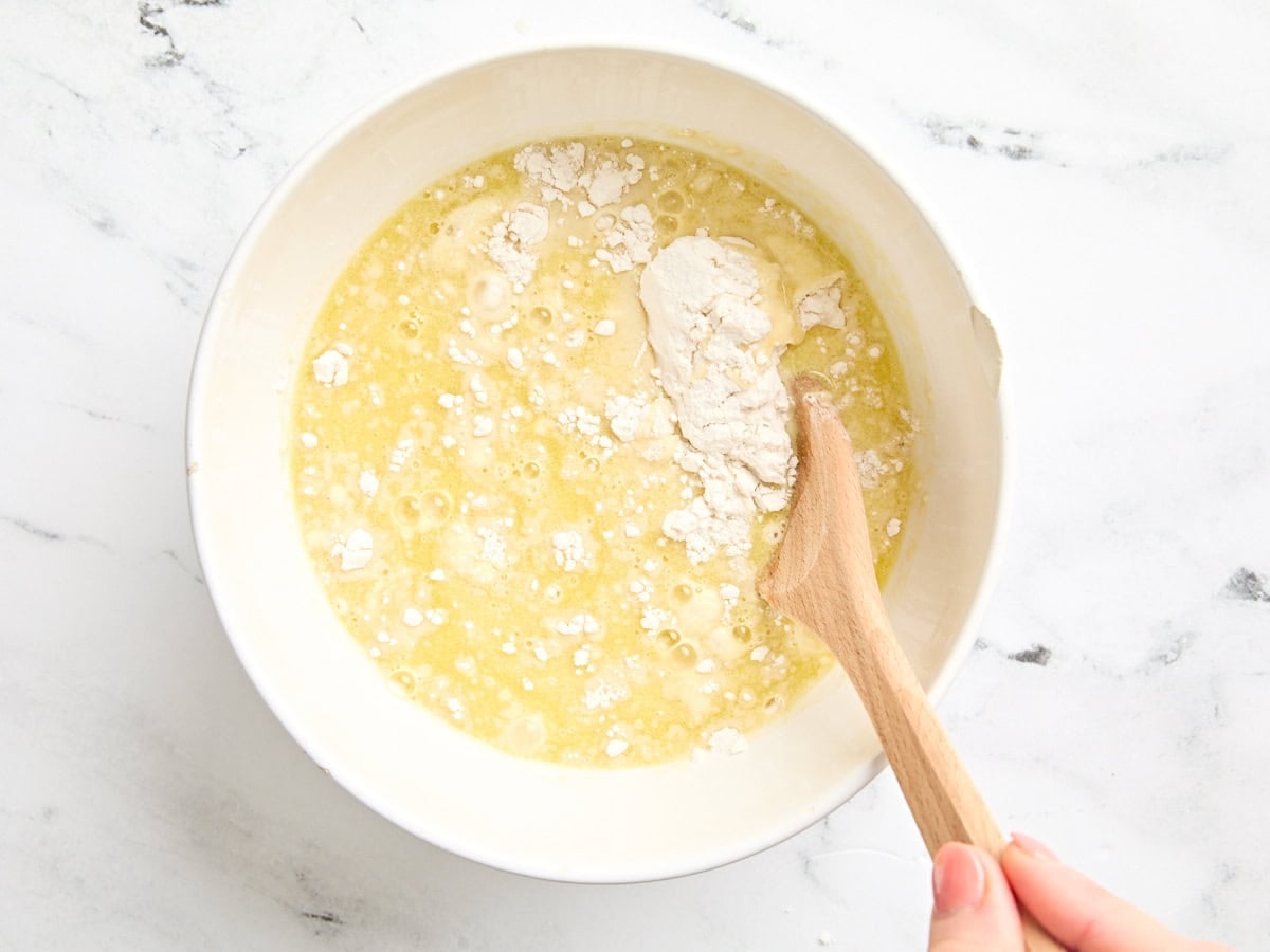 Flour being mixed into a yogurt, egg, and yeast mixture.