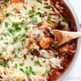 A skillet filled with cheesy gnocchi and herbs.