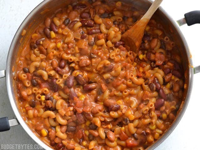 This rich and comforting One Pot Vegetarian Chili Mac and Cheese is the perfect quick and easy weeknight meal. Works great for meal prep! Budetbytes.com Overhead view of one pot vegetarian chili mac and cheese in the pot with a wooden spoon