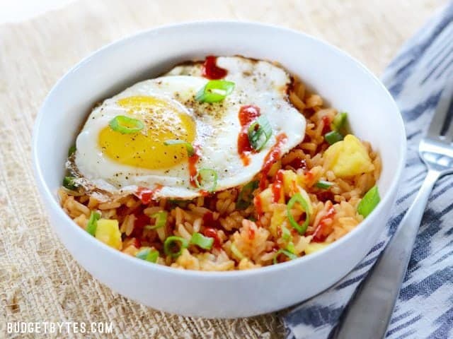 Use up the leftovers in your fridge with these fast and tasty Pineapple Sriracha Breakfast Bowls. Easy and customizable to fit what you have on hand. Budetbytes.com Side view of a finished Pineapple Sriracha Breakfast Bowl, fork on the side