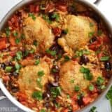 Skillet chicken with orzo and olives in a bowl.