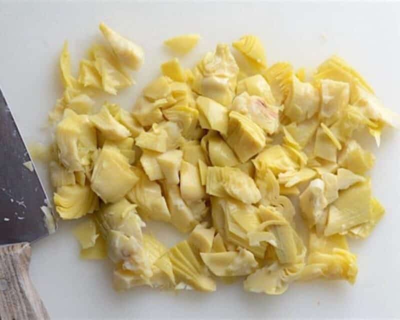 Chopped artichokes on a cutting board.