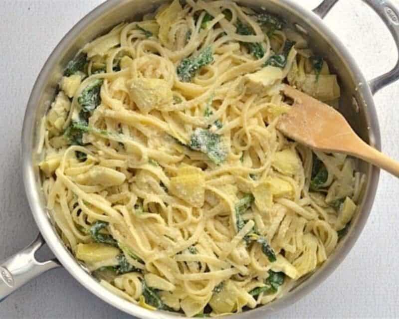 Parmesan added to the pasta in the skillet.