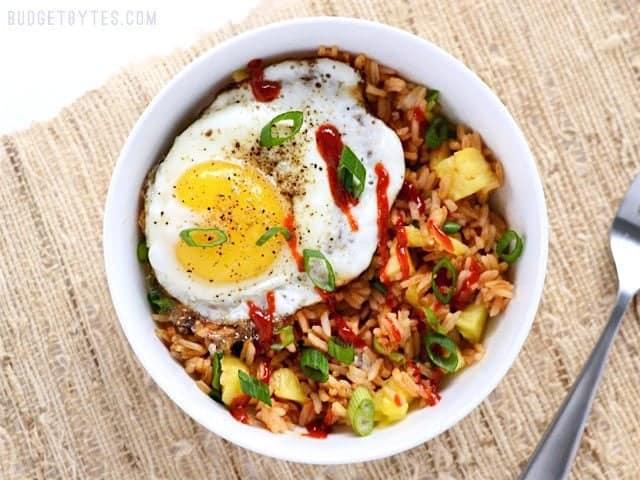 Use up the leftovers in your fridge with these fast and tasty Pineapple Sriracha Breakfast Bowls. Easy and customizable to fit what you have on hand. Budetbytes.com Bowl topped with Fried Egg