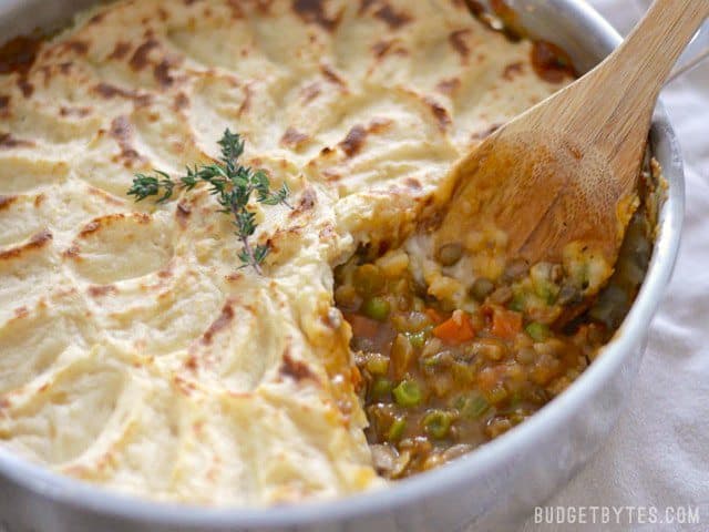 A colorful medley of vegetables, protein filled lentils, and a rich brown gravy make this Vegetarian Shepherd's Pie filling and flavorful without meat. Budetbytes.com Close up view of the vegetable, lentil, and brown gravy filling in the Vegetarian Shepherd's Pie.
