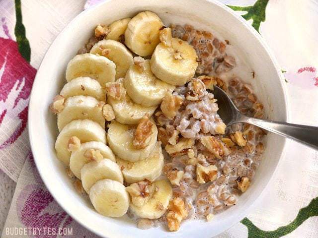 Oatmeal isn't the only grain that is great for breakfast! Take leftover cooked farro and turn it into this delicious Banana Nut Breakfast Farro bowl. Budetbytes.com A bowl of Banana Nut Breakfast Farro topped with sliced bananas and walnuts, a spoon in the center