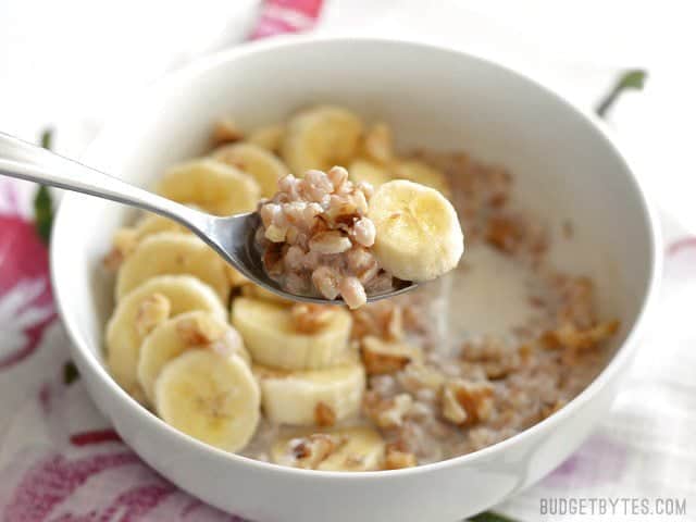 Oatmeal isn't the only grain that is great for breakfast! Take leftover cooked farro and turn it into this delicious Banana Nut Breakfast Farro bowl. Budetbytes.com Side view of a bowl of Banana Nut Breakfast Farro with a spoon lifting a bite toward the camera