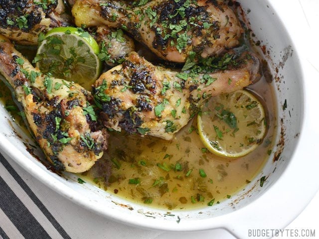 These garlicky Cilantro Lime Chicken Drumsticks are like a blast of summer to get you through those winter blues. Also great for the grill! Cilantro Lime Chicken Drumsticks in the baking dish with baking juices