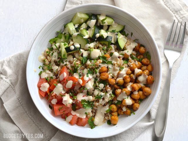 This Mediterranean Farro Salad with Spiced Chickpeas is a flavorful and filling vegan meal packed with tons of fiber and nutrients. Perfect for meal prep! Budetbytes.com Finished Mediterranean Farro Salad in a bowl