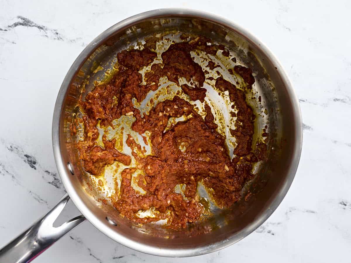 Sauteed red curry paste, garlic and ginger in a pan.