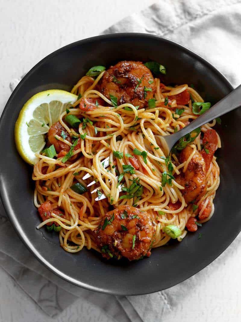 This quick and easy 30 minute Blackened Shrimp Pasta with homemade blackening seasoning boasts huge flavor without a lot of work. Budgetbytes.com A bowl of Blackened Shrimp Pasta with some wound around a fork and lemon slices on the side