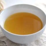 Instant pot chicken stock in a clear bowl.