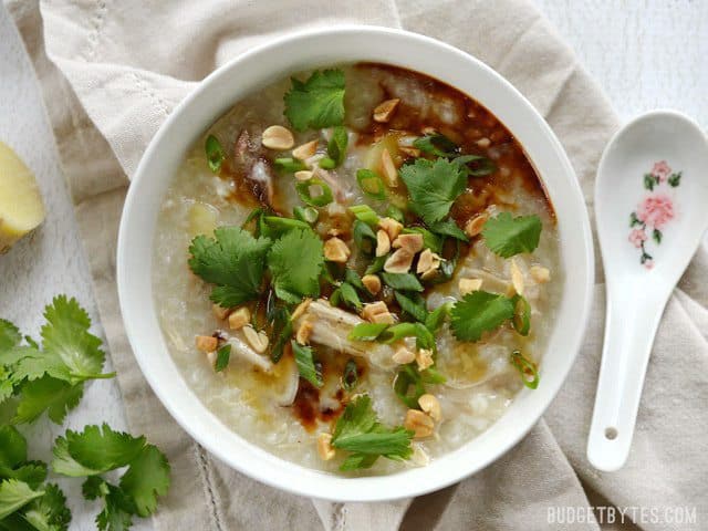 Instant Pot Congee is a warm and comforting rice porridge with endless possibilities for fun toppings. This classic dish is made easy with modern equipment. BudgetBytes.com A white bowl full of congee, topped with cilantro, peanuts, soy sauce, and sesame oil