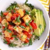 Close-up of sweet chili tofu bowls with toppings and chopsticks.