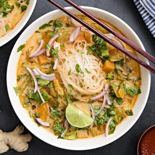 Overhead view of thai vegetable curry soup in a bowl with chopsticks.
