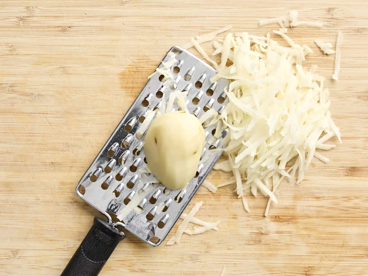A potato being shredded.