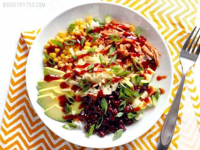 BBQ Chicken Burrito Bowls are an easy, customizable lunch option that is great both hot or cold! Vegetarian substitutions included. Great for meal prep! BudgetBytes.com A finished BBQ Chicken Burrito Bowl ready to eat