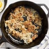 Overhead view of hashbrowns in a skillet.