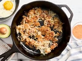Overhead view of hashbrowns in a skillet.
