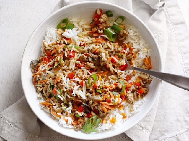 Hoisin Stir Fry Bowls with a rich and spicy peanut sauce are a fast answer to dinner with tons of color, texture, and flavor. Use pork, chicken, or turkey! BudgetBytes.com Stirred up bowl of hoisin stir fry, a fork stuck in the middle