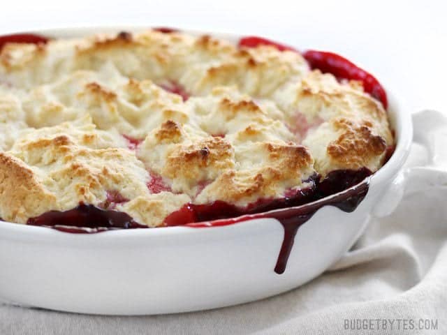 With the perfect mix of sweet and tart, this Lemon Berry Cobbler is the fastest and easiest way to sweet dessert satisfaction. Step by step photos. BudgetBytes.com Side view of the baked Lemon Berry Cobbler with a bright berry juice drip down the side of the casserole dish