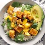 Close-up of mango coconut tofu bowl with toppings.