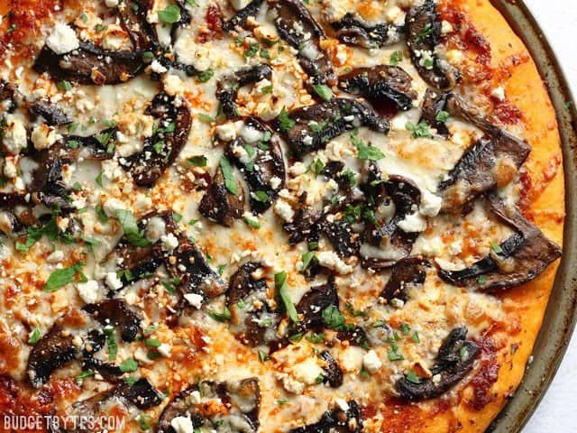 Make this gourmet homemade Portobello Mushroom Pizza for a fraction of the price of take out! Use homemade dough for the best value, or store bought for convenience. BudgetBytes.com Close up overhead view of the Ultimate Portobello Mushroom Pizza still in the pizza pan