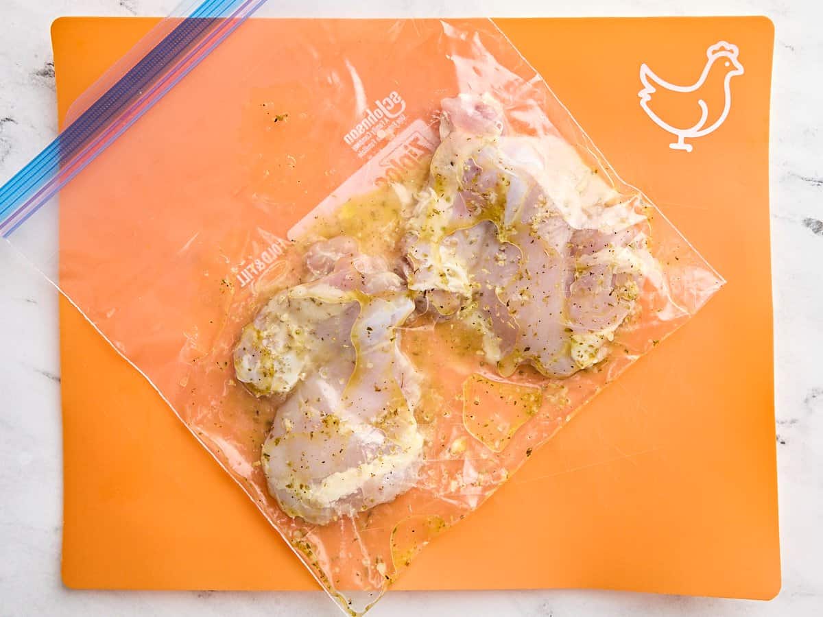 Chicken thighs in a ziplock bag with lemon marinade.