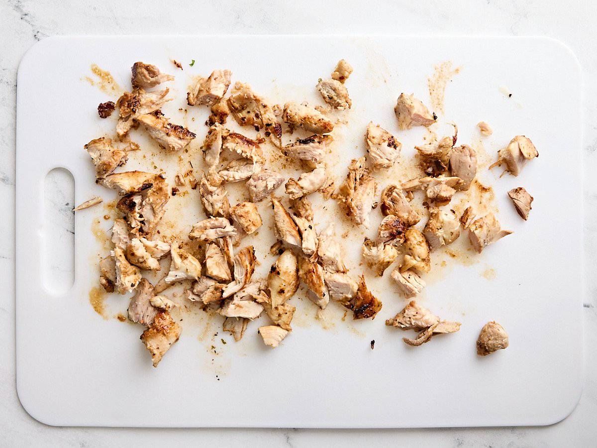 Diced cooked chicken thighs on a cutting board.