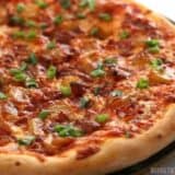 Bacon and caramelized onion pizza on a plate.