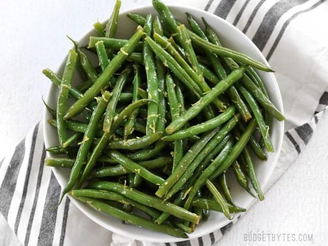 Lemon Butter Green Beans are an easy and flavorful way to cook fresh green beans, and a great all-purpose side dish for all your meals. BudgetBytes.com A large bowl full of Lemon Butter Green Beans garnished with lemon zest, viewed from above