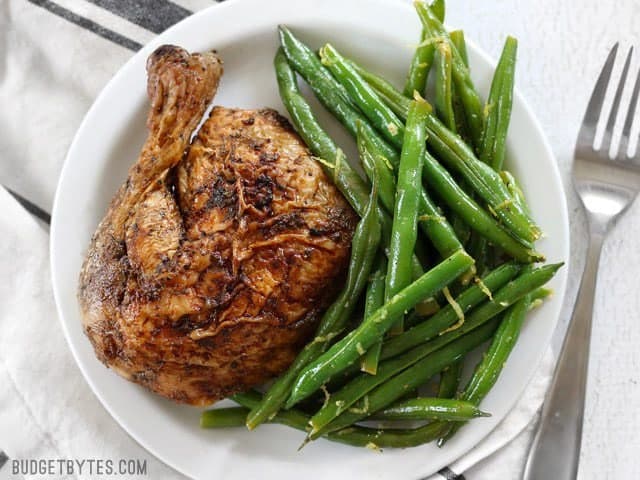 Lemon Butter Green Beans are an easy and flavorful way to cook fresh green beans, and a great all-purpose side dish for all your meals. BudgetBytes.com Overhead view of a plate full of Lemon Butter Green Beans and roasted chicken