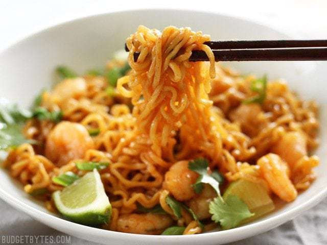 These spicy Lime Shrimp Dragon Noodles are a fast, easy, and inexpensive alternative to take out. This version features tender shrimp and fresh lime. BudgetBytes.com Chopsticks picking up a clump of Lime Shrimp Dragon Noodles out of the bowl