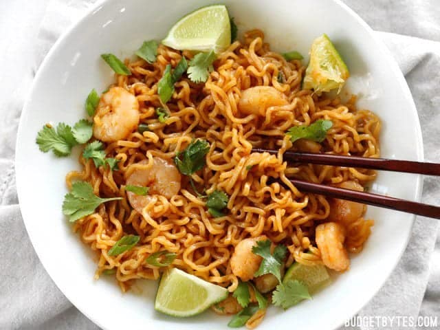 These spicy Lime Shrimp Dragon Noodles are a fast, easy, and inexpensive alternative to take out. This version features tender shrimp and fresh lime. BudgetBytes.com Overhead view of a bowl full of Lime Shrimp Dragon Noodles with chopsticks
