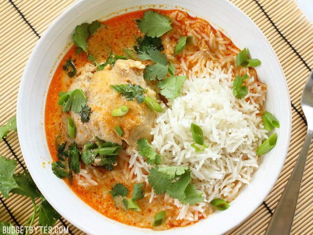 Thai Coconut Curry Chicken Thighs are easy to prepare but still have a bold flavor from Thai red curry paste, and a rich, comforting coconut curry broth. BudgetBytes.com A bowl of Thai Coconut Curry Braised Chicken Thighs served with jasmine rice and cilantro