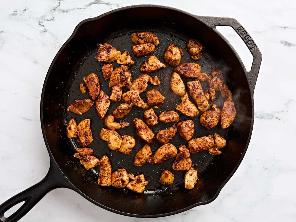 Chicken cooking in a skillet.