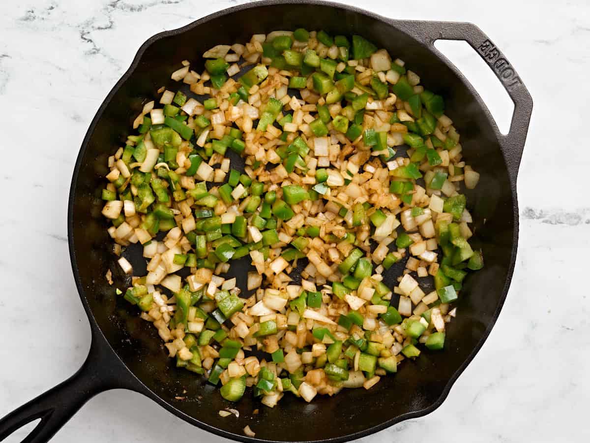 Diced onion and green bell pepper in a skillet.