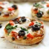 Baked mini pizzas ready for the freezer on a plate.