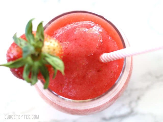 This Strawberry Rosé Slush is a fast and inexpensive frozen drink made with wine and fruit that you can enjoy all summer. No fancy ingredients required! BudgetBytes.com Finished Strawberry Rosé Slush in a glass, from above