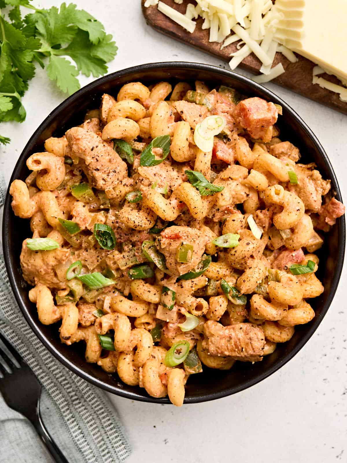 Creamy Chicken Fajita Pasta is a fast and delicious weeknight meal with spicy southwest flavors and a rich creamy sauce that the whole family will love. BudgetBytes.com Overhead view of a bowl of creamy chicken fajita pasta.