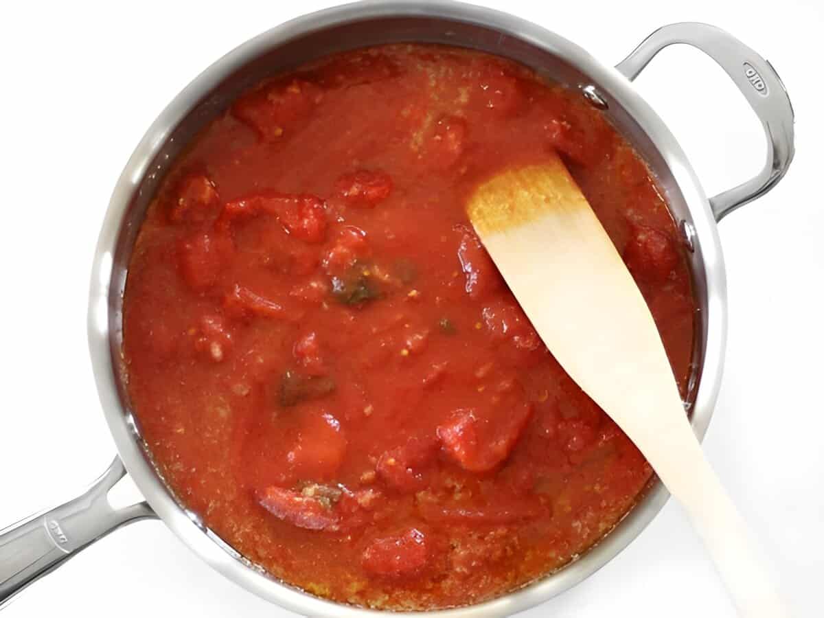 The ingredients for butter tomato sauce in a skillet with a spatula.