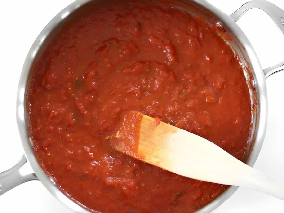 5 ingredient butter tomato sauce in a skillet with a spatula after simmering.