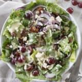 Grape, feta, and bacon salad drizzled with dressing.