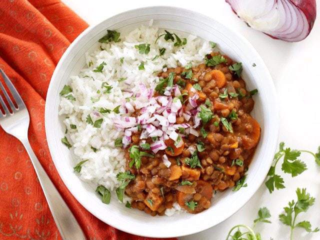 Slow Cooker Coconut Curry Lentils are a hands-off, fiber filled, freezer friendly vegan dinner. Budgetbytes.com Finished bowl of Slow Cooker Coconut Curry Lentils topped with red onion and cilantro