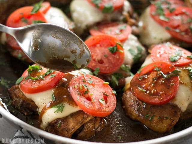 A simple marinade, creamy mozzarella, and fresh tomatoes turn simple chicken thighs into a fast and easy weeknight dinner in this Balsamic Chicken Skillet. BudgetBytes.com Balsamic glaze being drizzled over a piece of chicken with mozzarella and tomatoes