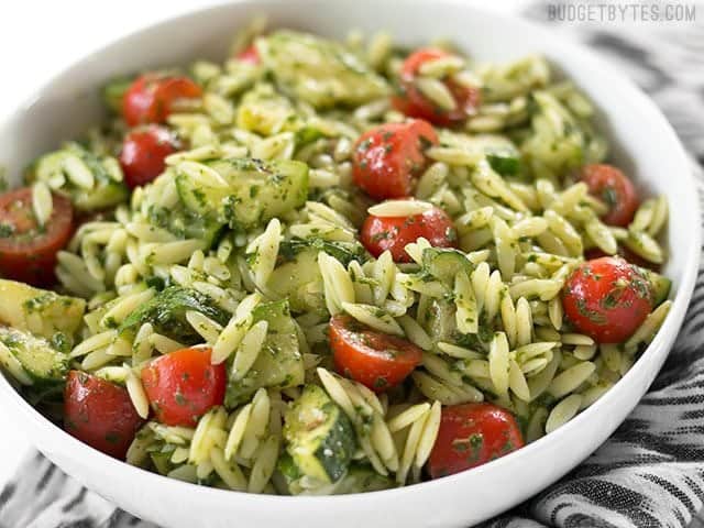 Zucchini and Orzo Salad with Chimichurri is a fresh summer salad that makes the perfect fresh and zesty side dish for summer grilling. BudgetBytes.com Side view of a bowl full of Zucchini and Orzo Salad with Chimichurri