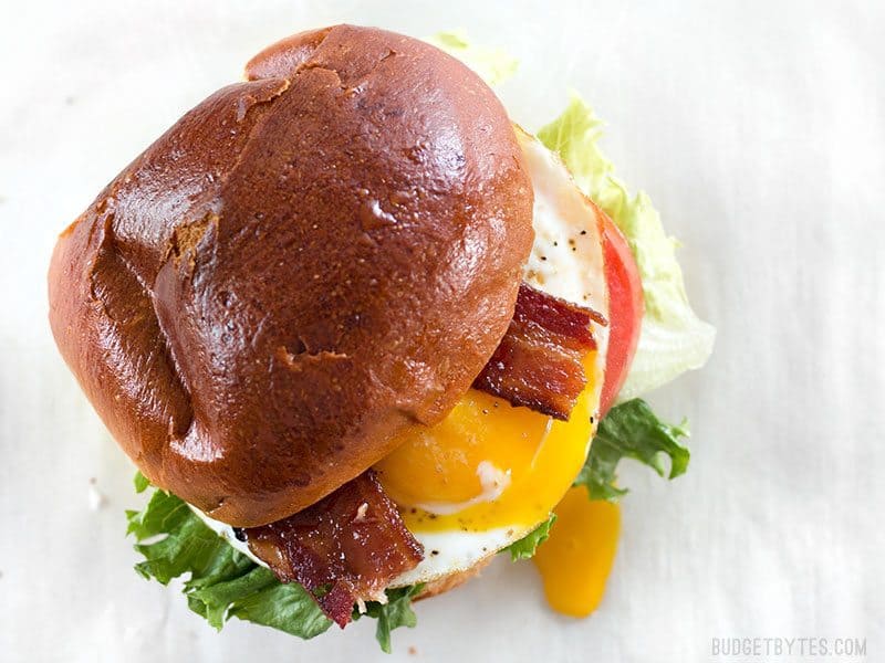 Brown Sugar Bacon Breakfast Sandwiches with Chipotle Mayo are the perfect mix of salty, sweet, and spicy for your weekend brunch. BudgetBytes.com Overhead view of a Brown Sugar Bacon Breakfast Sandwiches with the yolk dripping down the side