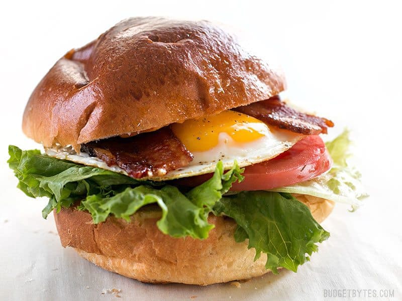 Brown Sugar Bacon Breakfast Sandwiches with Chipotle Mayo are the perfect mix of salty, sweet, and spicy for your weekend brunch. BudgetBytes.com Finished Brown Sugar Bacon Breakfast Sandwiches with Chipotle Mayo viewed from the side